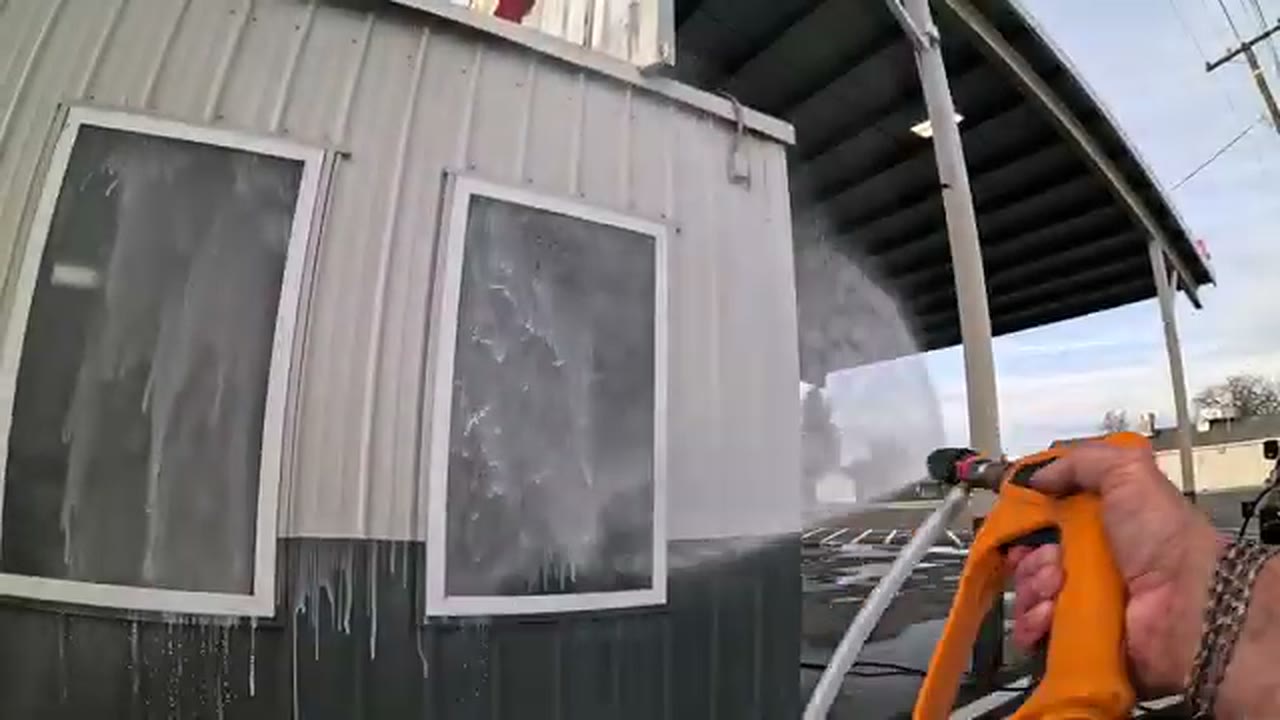 Rinsing the exterior wall and windows during an after-hours commercial cleaning job